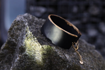 Handcrafted Black Moon Bracelet with a smooth matte black band and a bold gold crescent closure, inspired by lunar symbolism, feminine protection, and modern minimal celestial jewelry, available at Soul and Sage.