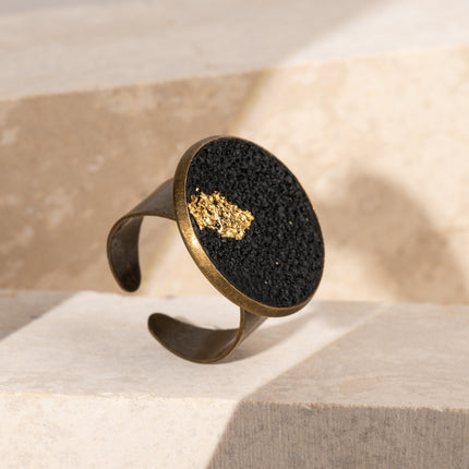 Handcrafted Black Moon Flat Ring made of deep matte black polymer clay with a genuine gold leaf accent, inspired by lunar cycles, shadow and light, and modern celestial jewelry, available at Soul and Sage.