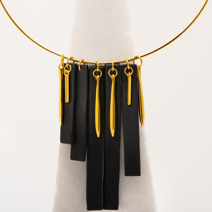 Handcrafted Black Moon Lines Necklace with matte black elongated bar pendants, a gold-tone curved collar, and gold-plated charms inspired by new moon symbolism, celestial geometry, and lunar energy, available at Soul and Sage.