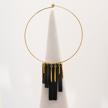 Handcrafted Black Moon Lines Necklace with matte black elongated bar pendants, a gold-tone curved collar, and gold-plated charms inspired by new moon symbolism, celestial geometry, and lunar energy, available at Soul and Sage.