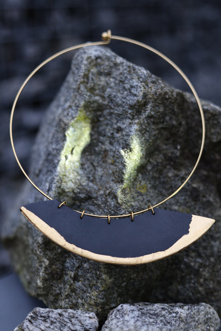 Handcrafted Black Moon Necklace with a smooth matte black crescent pendant framed in a circular gold-tone hoop, inspired by new moon symbolism, lunar protection, and celestial minimalism, available at Soul and Sage.