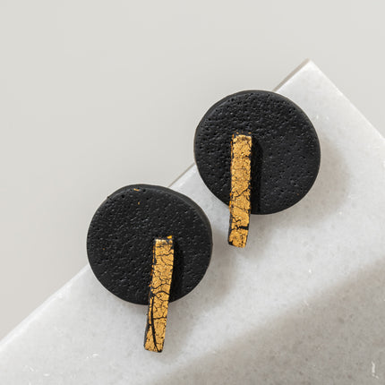 Handcrafted black and gold Circle Line earrings with matte black circular shapes and a vertical gold line detail, inspired by lunar cycles and modern femininity, available at Soul and Sage.
