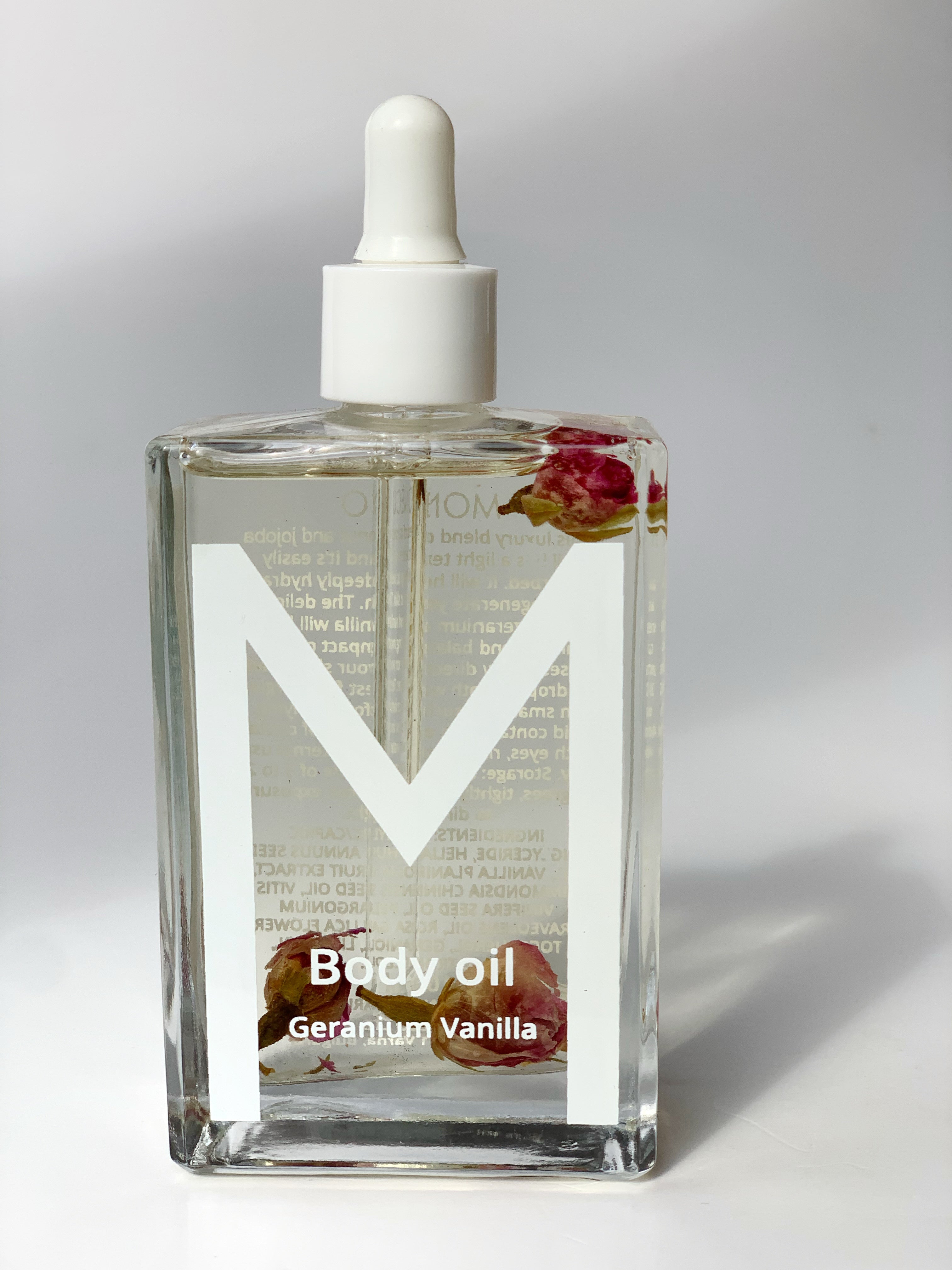 Bottle of Sacred Embrace Geranium & Vanilla Body Oil, a luxurious blend that hydrates, soothes, balances emotions, and awakens feminine radiance with a soft floral-vanilla fragrance